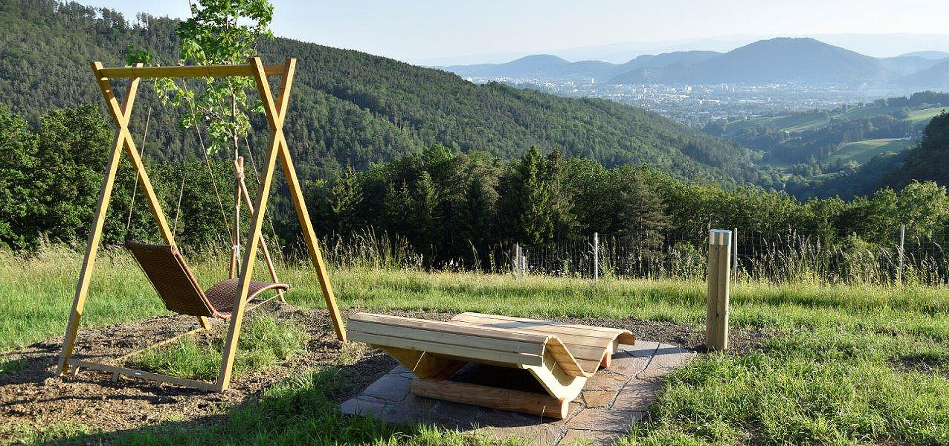 Bild zeigt Schaukel und Sitzbank mit Bergpanorama am Eisenbergerhof.