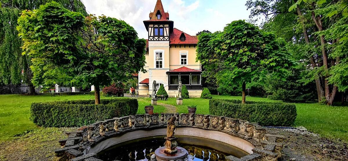 Bild zeigt Außenansicht des großen Parks mit Brunnen am Glögglhof.