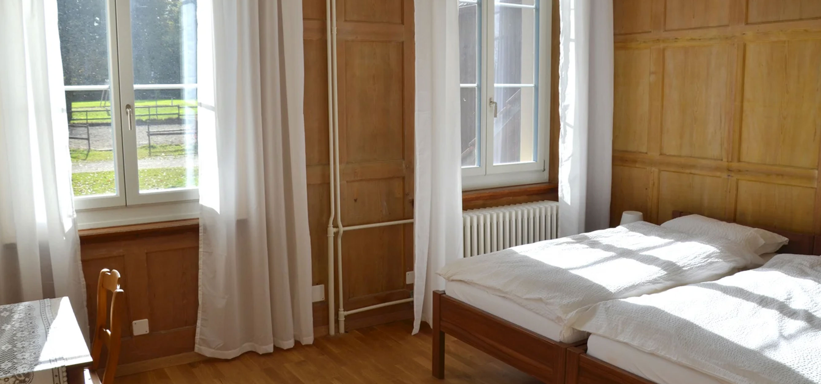 Bild zeigt Zweibettzimmer mit Holzmöbel im Landgut Ried.